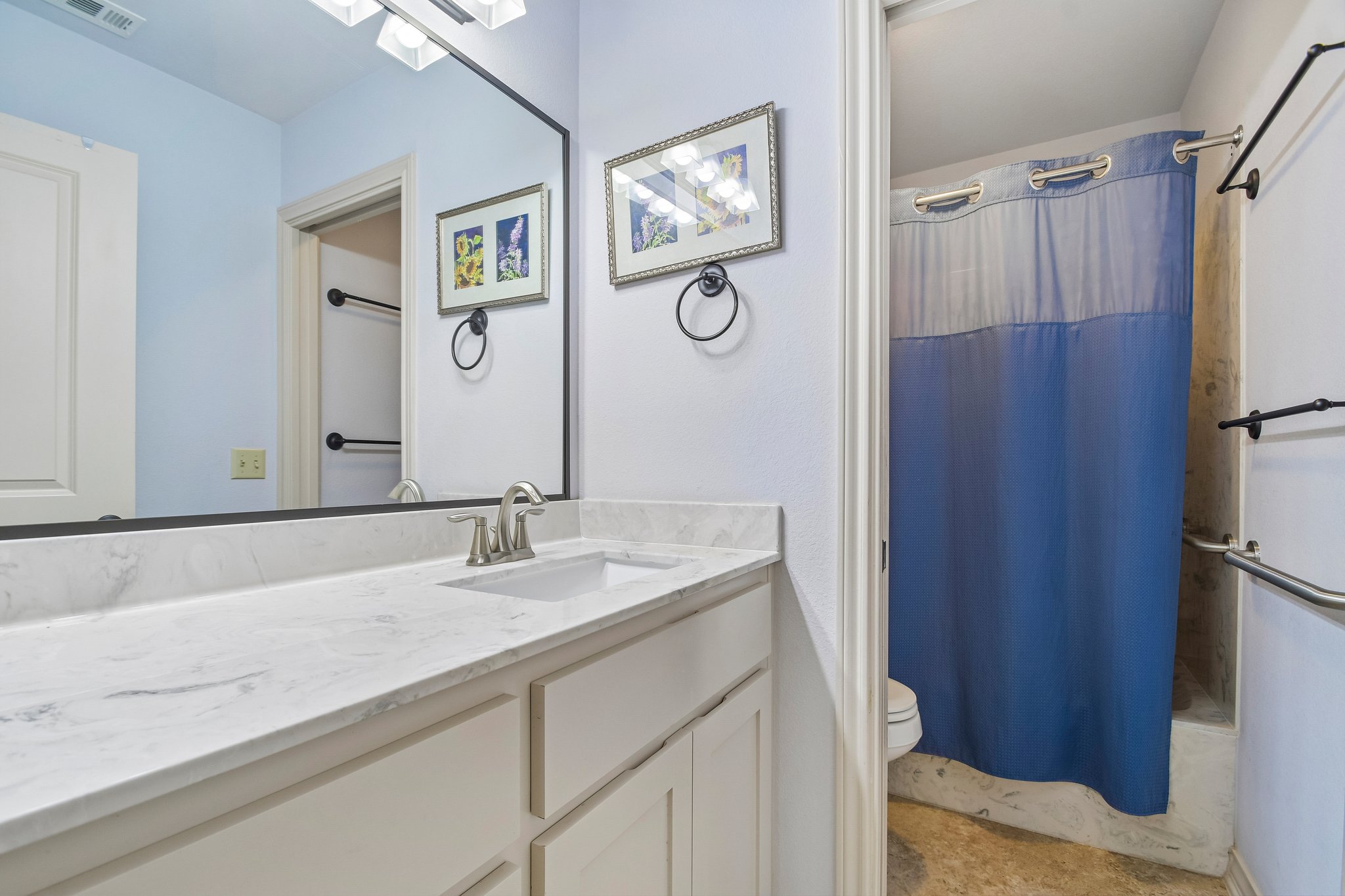 307 West 4th Street Elgin, TX 78621 - Photo 30 of 40 Bathroom vanity with a white rectangular undermount sink and a polished chrome faucet, set into a white countertop