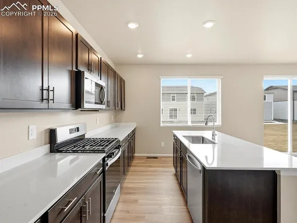 a kitchen with stainless steel appliances a sink stove and cabinets