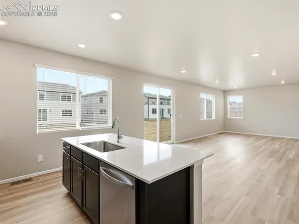 a kitchen with stainless steel appliances granite countertop a sink and a large window