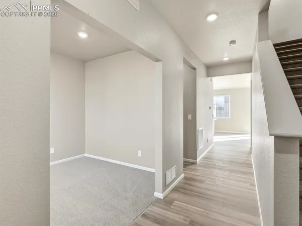 a view of hallway with stairs and wooden floor