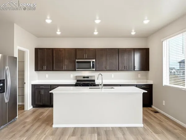 a kitchen with stainless steel appliances a sink a stove a microwave and cabinets