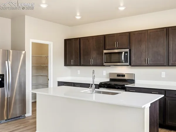 a kitchen with stainless steel appliances a stove microwave and sink