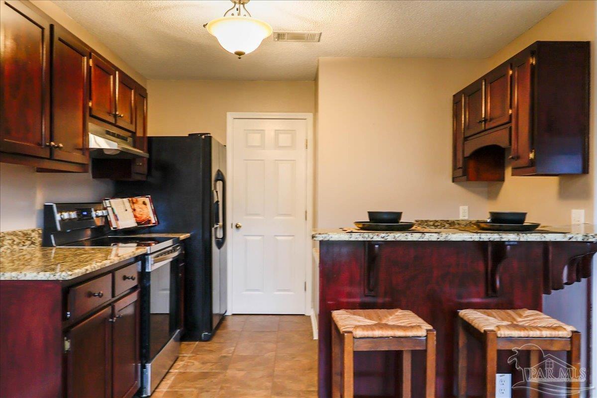 3256 Two Sisters Way Pensacola, FL 32505 - Photo 14 of 40 a kitchen with stainless steel appliances granite countertop a stove and a refrigerator