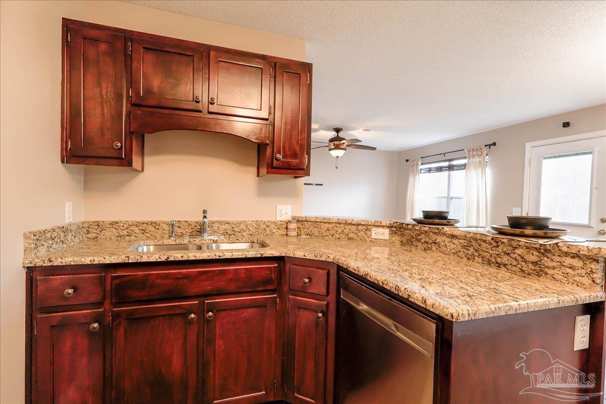 3256 Two Sisters Way Pensacola, FL 32505 - Photo 18 of 40 a kitchen with granite countertop wood cabinets and a sink