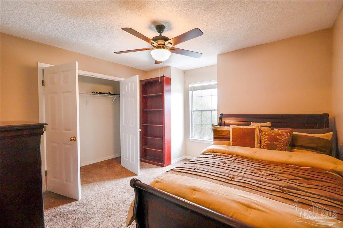 3256 Two Sisters Way Pensacola, FL 32505 - Photo 32 of 40 a bedroom with a bed and a chandelier