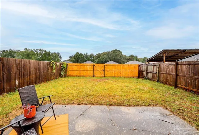a view of a house with a yard and wooden fence