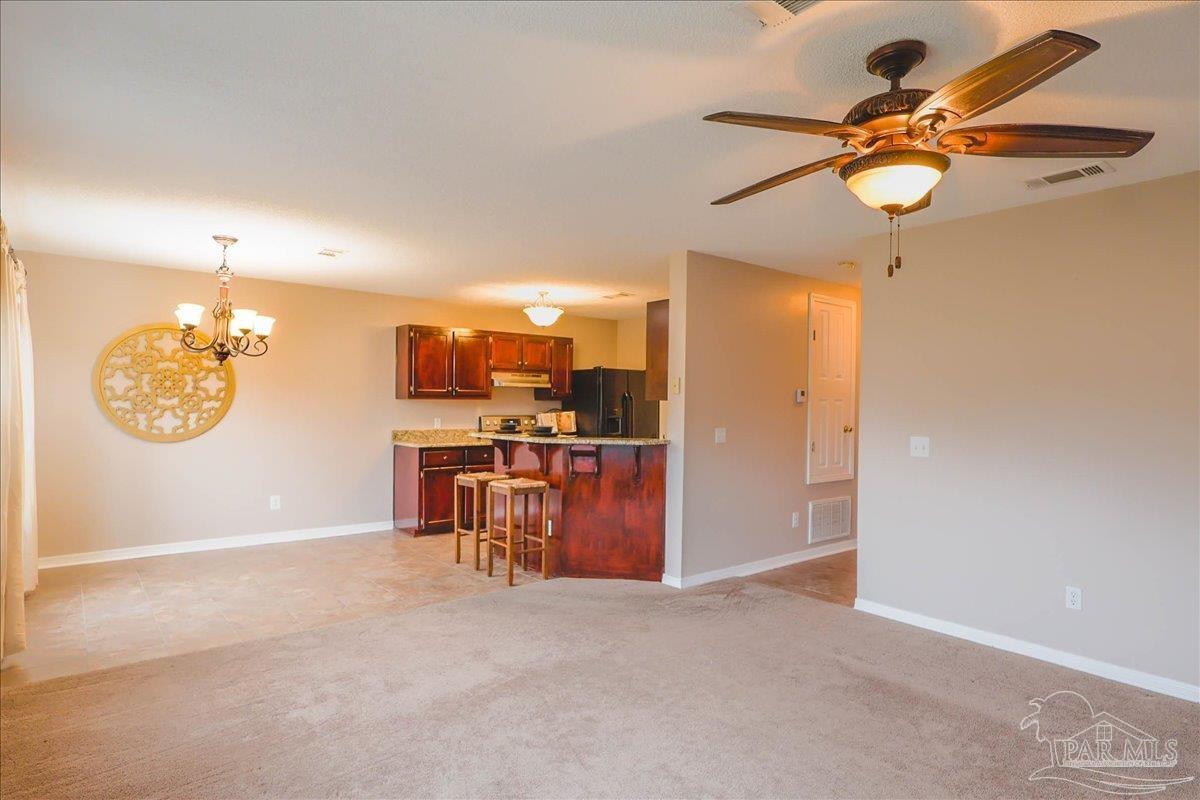 3256 Two Sisters Way Pensacola, FL 32505 - Photo 6 of 40 a view of a kitchen with a refrigerator and a chandelier
