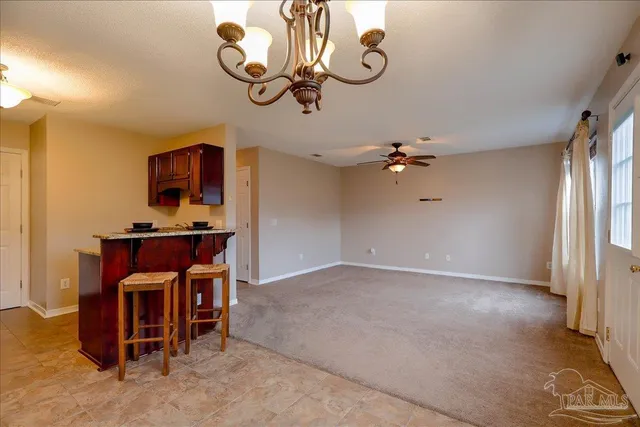 a view of a room with a chandelier fan and windows