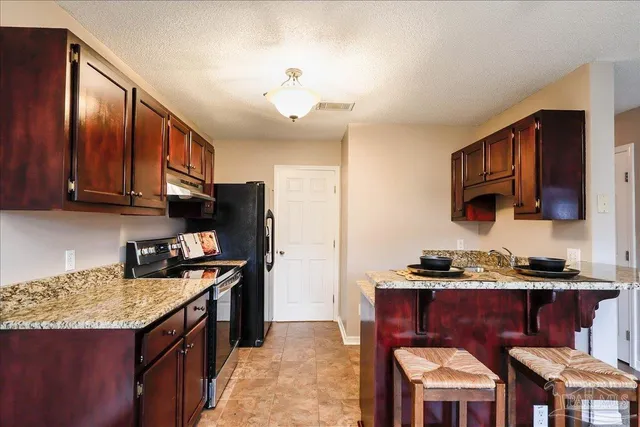 a kitchen with stainless steel appliances granite countertop a stove top oven a refrigerator a sink and dishwasher
