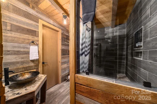 a bathroom with a granite countertop sink a mirror and shower