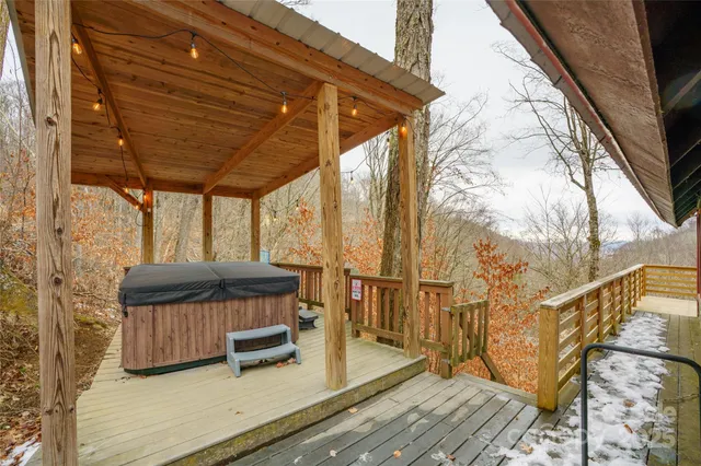 a view of roof deck with table and chairs with wooden floor and fence