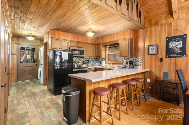 a kitchen with stainless steel appliances kitchen island granite countertop a table chairs and a refrigerator