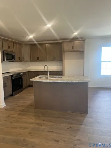 a kitchen with stainless steel appliances granite countertop a stove top oven sink and cabinets