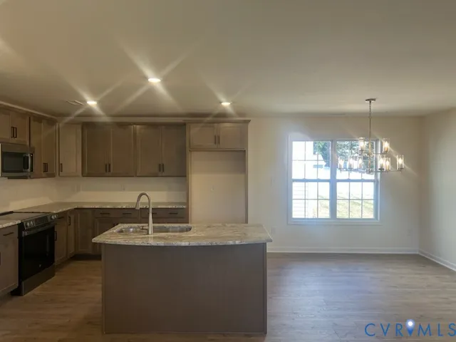 a large kitchen with stainless steel appliances granite countertop a sink and a stove
