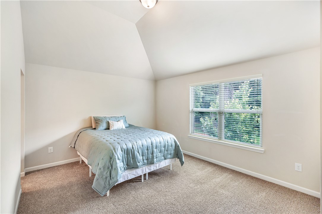 144 Buckland Drive Anderson, SC 29621 - Photo 21 of 48 A tranquil bedroom with soft carpet, bathed in natural light through a generous window overlooking lush greenery.