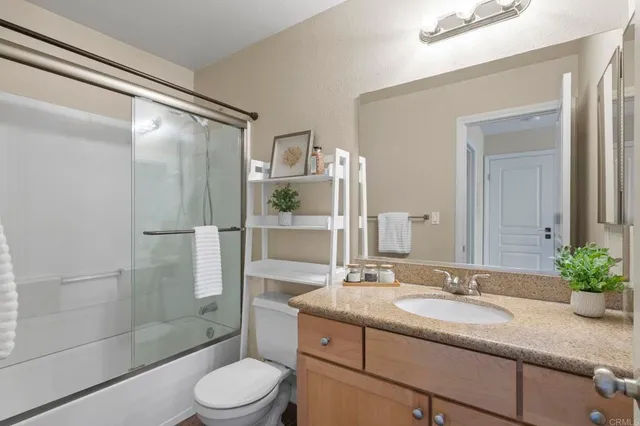 a bathroom with a granite countertop sink toilet a mirror and shower