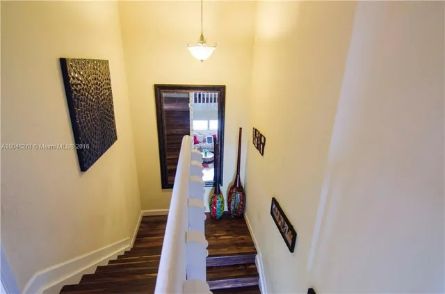 a view of a hallway with wooden floor and stairs