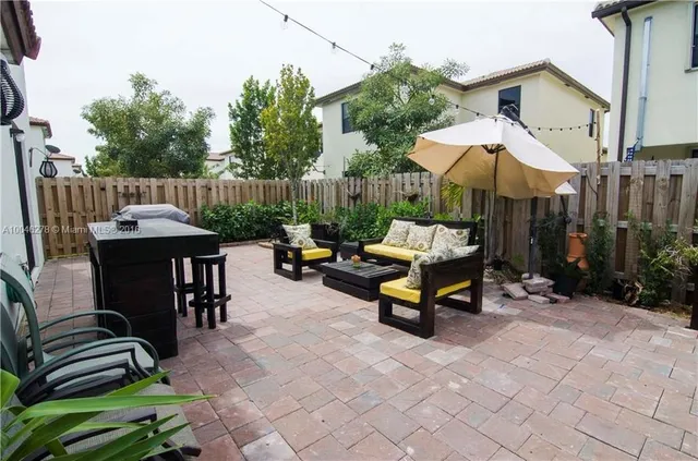 a backyard of a house with barbeque oven table and chairs
