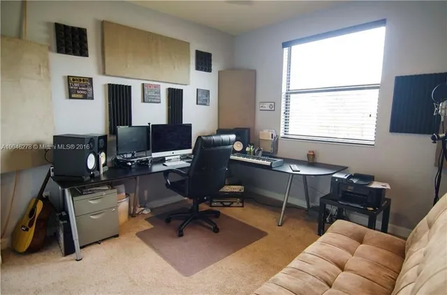 a view of a livingroom with workspace and a window