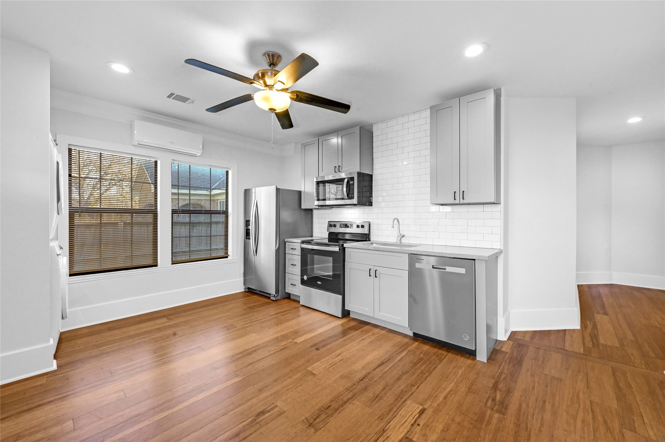 1633 Fourcade Street, Unit A Houston, TX 77023 - Photo 2 of 7 a kitchen with stainless steel appliances granite countertop a stove top oven a refrigerator a sink and dishwasher with wooden floor