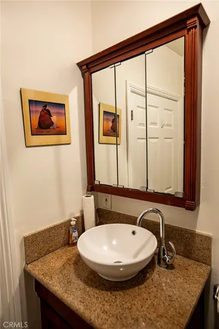 a bathroom with a granite countertop sink and a mirror