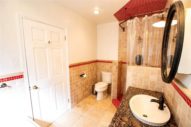 a bathroom with a toilet a sink and mirror