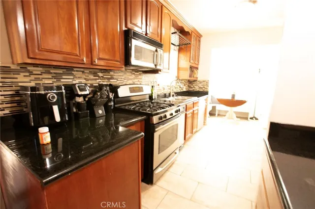 a kitchen with stainless steel appliances granite countertop a stove and cabinets