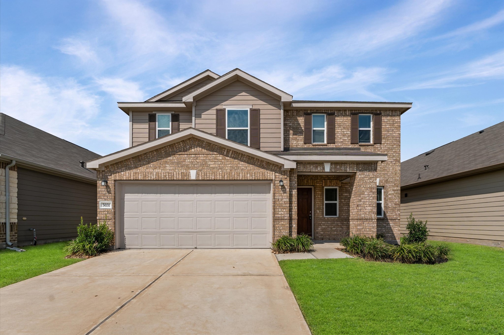 a front view of a house with a yard and garage
