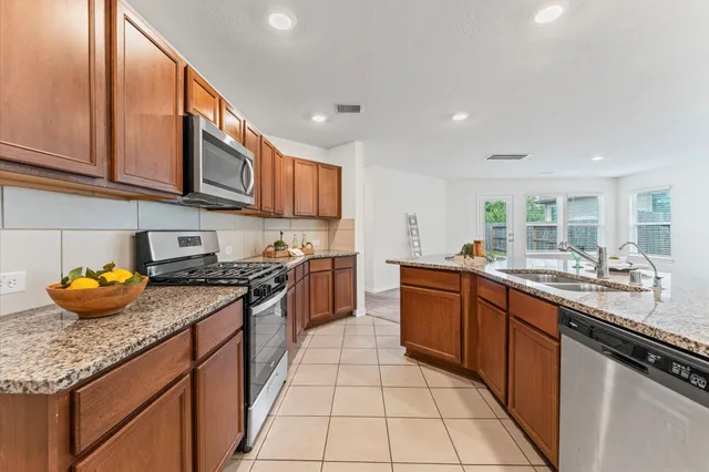 a kitchen with stainless steel appliances granite countertop a sink and stove