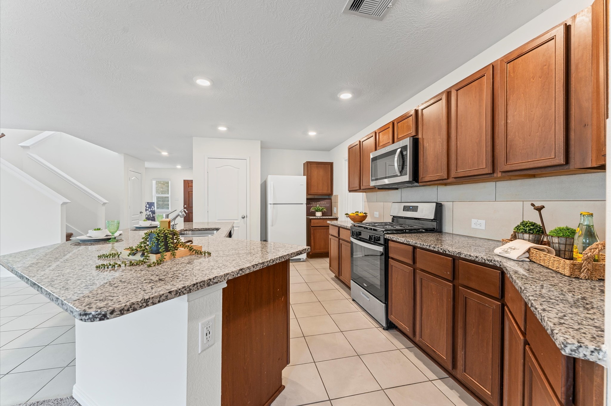 5031 Gazelle Leap Lane Richmond, TX 77406 - Photo 13 of 30 a kitchen with stainless steel appliances granite countertop a sink stove and cabinets