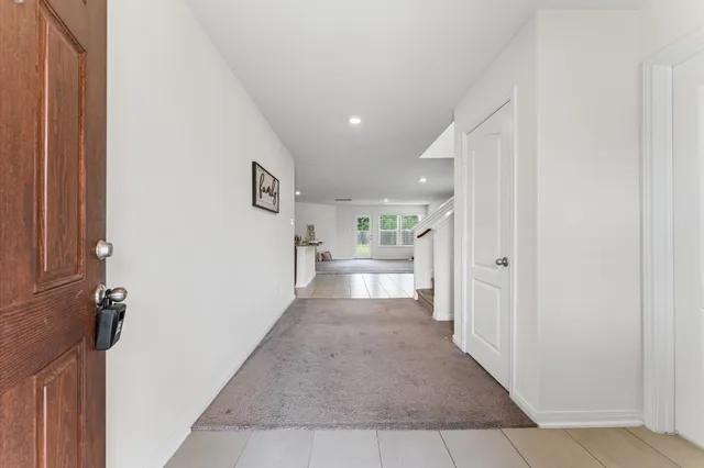 a view of a hallway with a livingroom and a bathroom