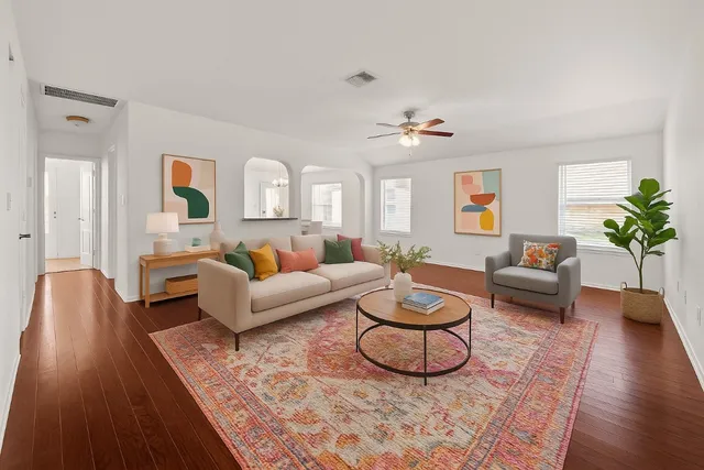 a living room with furniture a rug potted plant and a fireplace