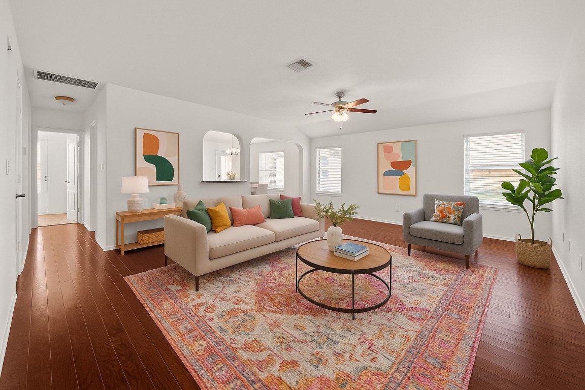 a living room with furniture a rug potted plant and a fireplace