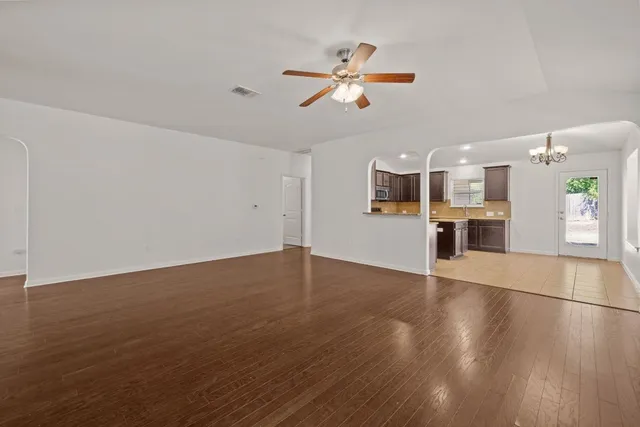 a view of a kitchen with a microwave and an empty room