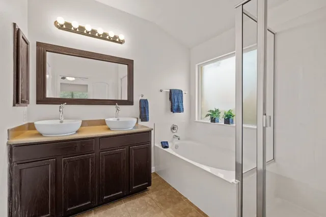 a bathroom with a tub a sink and mirror