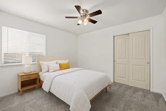 a bedroom with a bed and a ceiling fan
