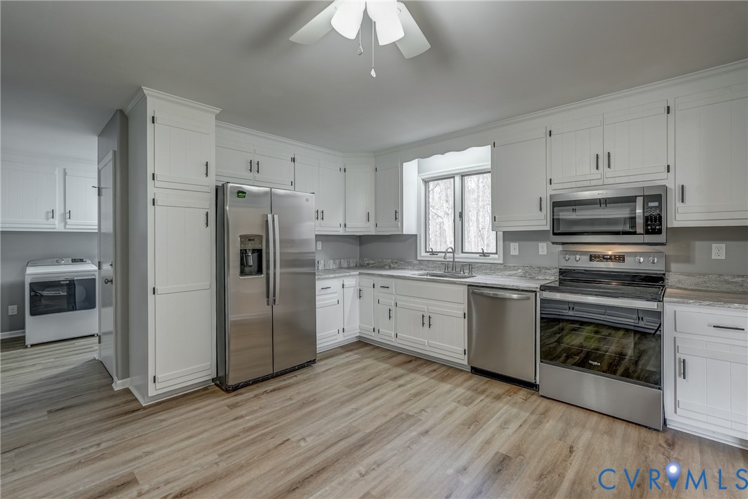 3534 Davis Mill Road Goochland, VA 23063 - Photo 19 of 40 a kitchen with granite countertop a refrigerator oven a sink dishwasher and white cabinets with wooden floor
