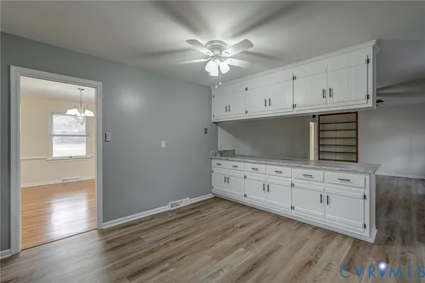 a kitchen with granite countertop white cabinets and stainless steel appliances