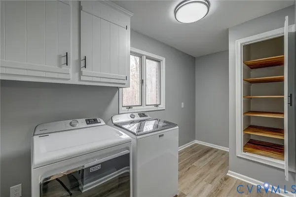 an empty room with windows and fireplace