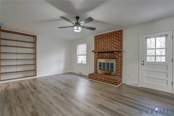 a living room with fireplace furniture and a wooden floor