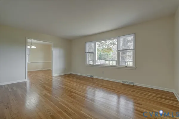 a view of wooden floor chandelier and window in a room