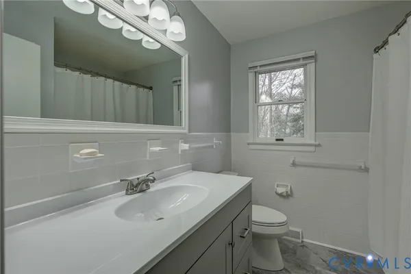 a bathroom with a sink toilet and mirror