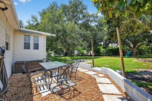 a view of a patio with a table chairs and a backyard