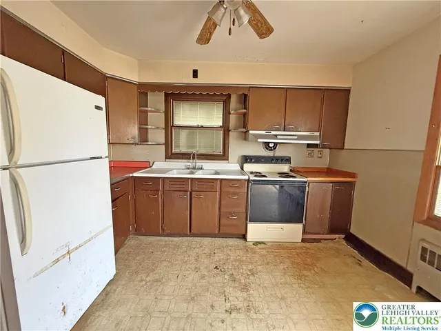 a kitchen with stainless steel appliances a stove a sink and a refrigerator