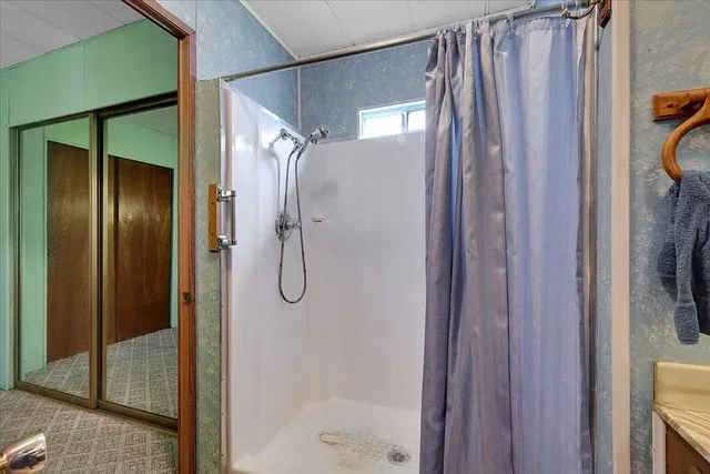 a bathroom with a shower and a glass door