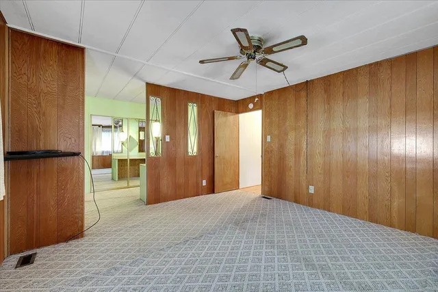 a view of a livingroom with a chandelier fan and wooden floor