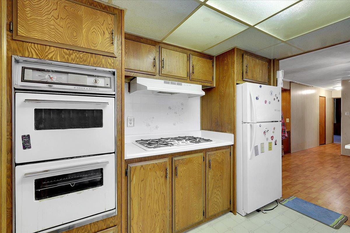 10383 Larkin Road, Unit 43 Live Oak, CA 95953 - Photo 9 of 26 a kitchen with stainless steel appliances a refrigerator a stove and white cabinets