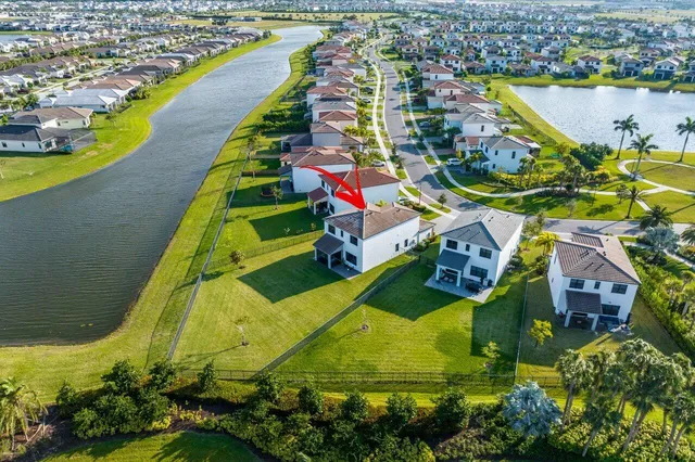 an aerial view of residential houses with outdoor space and lake view