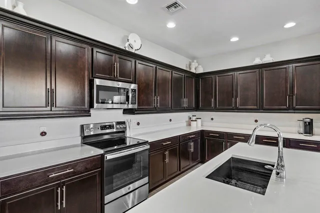 a kitchen with granite countertop stainless steel appliances and sink