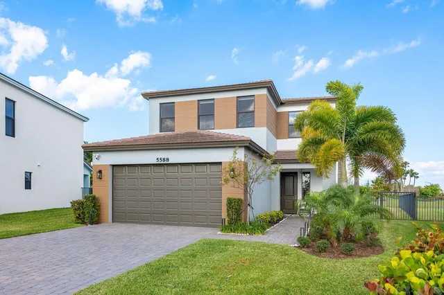 a front view of a house with a garden and plants